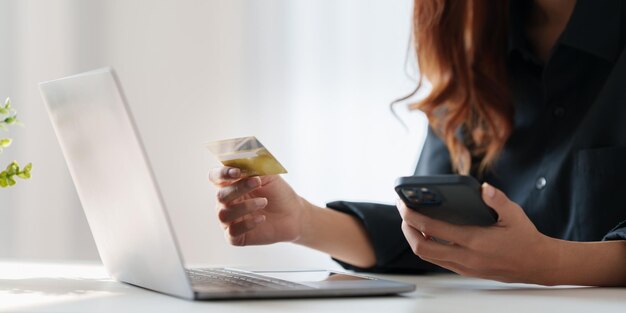 Vrouw die online betaling gebruikt en creditcard online shopping-concept vasthoudt