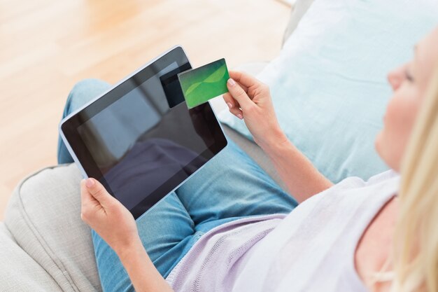 Vrouw die online thuis het winkelen op digitale tablet doen