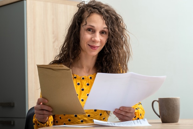 Vrouw die ontvangen post thuis bekijkt