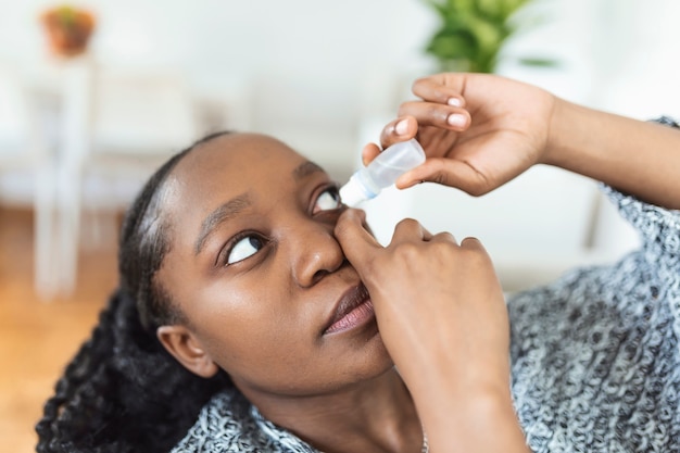 Vrouw die oogdruppels gebruikt, vrouw die oogsmeermiddel laat vallen om droge ogen of allergie te behandelen, zieke vrouw die oogbalirritatie of -ontsteking behandelt Vrouw die lijdt aan geïrriteerde ogen, optische symptomen