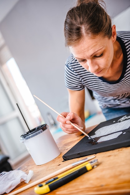 Foto vrouw die op canvas schildert