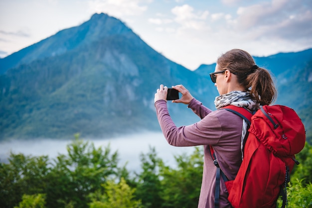 Vrouw die op de berg wandelt en beelden met slimme telefoon neemt