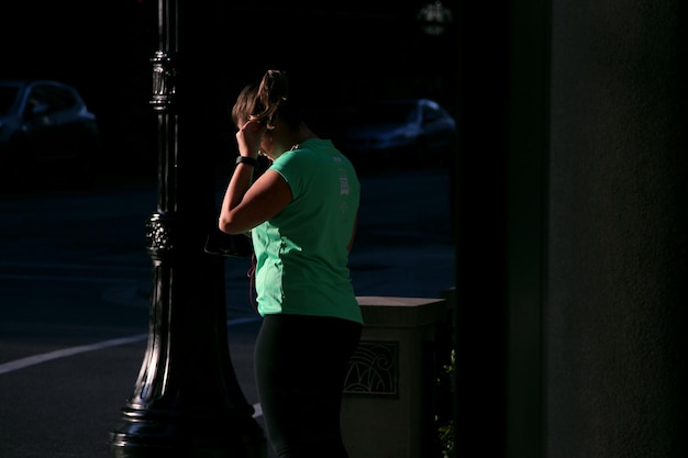 Foto vrouw die op de stoep staat in de stad