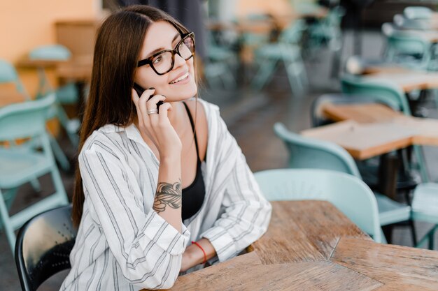 Vrouw die op de telefoon in koffie spreekt