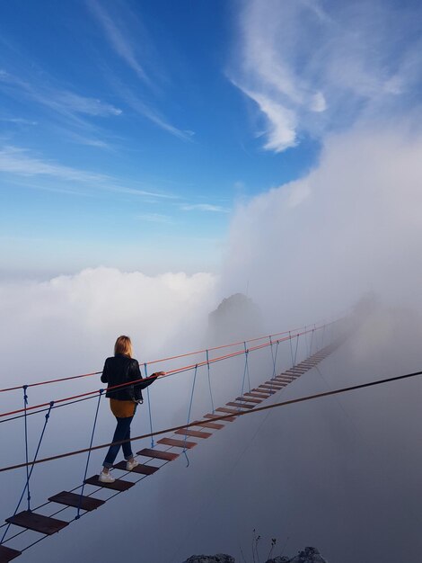 Foto vrouw die op een brug tegen de lucht staat.