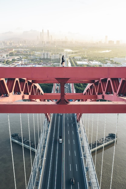 Foto vrouw die op een kabelbrug over een rivier in de stad staat