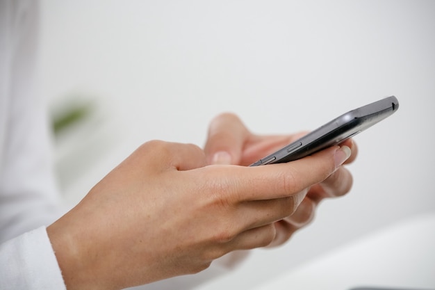 Foto vrouw die op een mobiele telefoontoets typt in alledaagse sociale netwerken