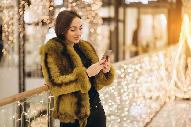 Vrouw die op een telefoon in een winkelcentrum spreekt