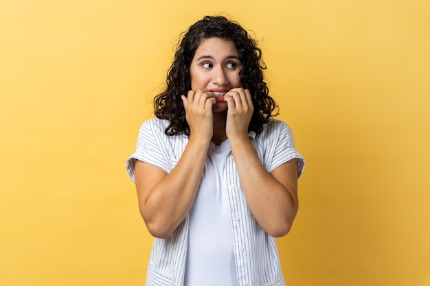 Vrouw die op haar nagels bijt en zich zorgen maakt over problemen slechte gewoonte als gevolg van stress en depressie