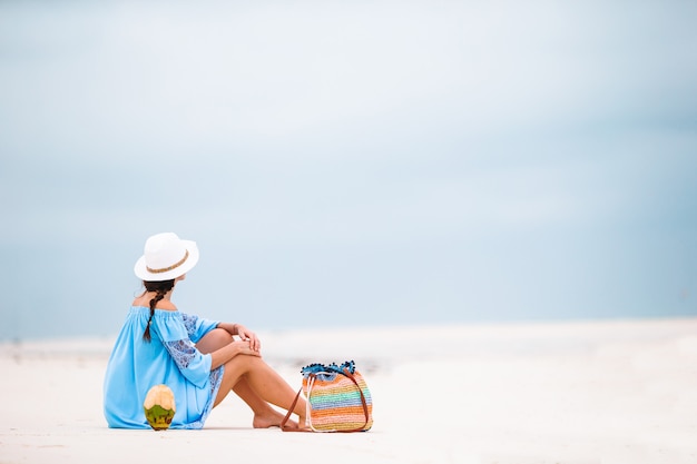 Vrouw die op het strand legt dat van de zomervakantie geniet bekijkend het overzees