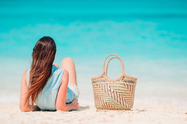 Vrouw die op het strand legt dat van de zomervakantie geniet die het overzees bekijkt