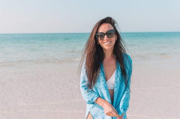 Vrouw die op het strand legt dat van de zomervakantie geniet