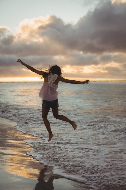 Vrouw die op het strand springt