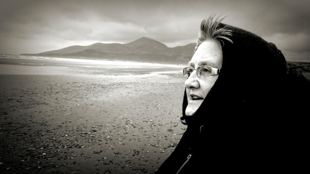 Foto vrouw die op het strand staat.