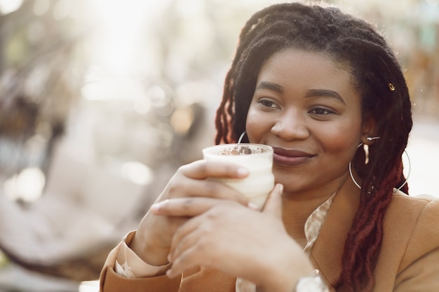 vrouw die op het terras zit en koffie drinkt