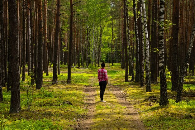 Foto vrouw die op het voetpad in het bos staat