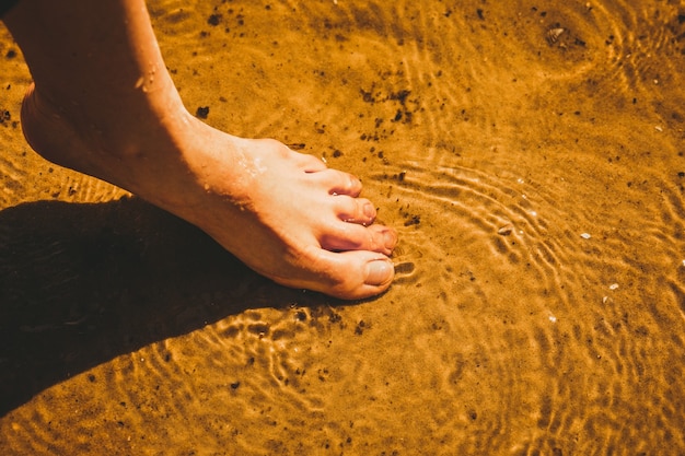 Vrouw die op het zand in de rivier loopt