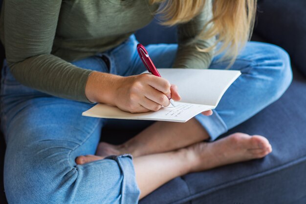 Vrouw die op laag thuis schrijft