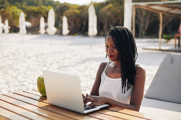 Vrouw die op laptop buitenshuis werkt