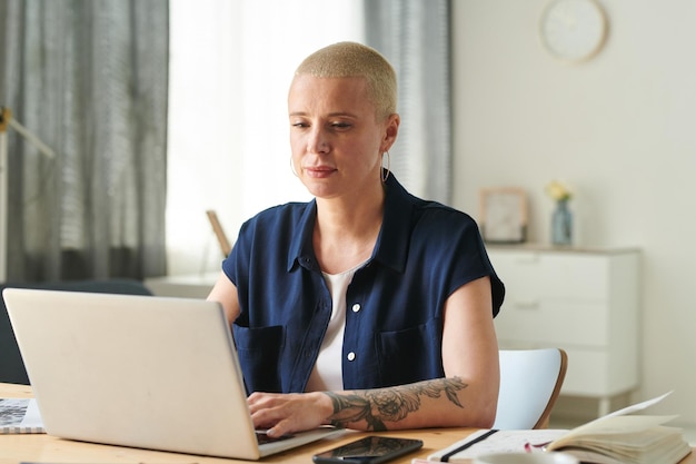 Vrouw die op laptop thuis werkt