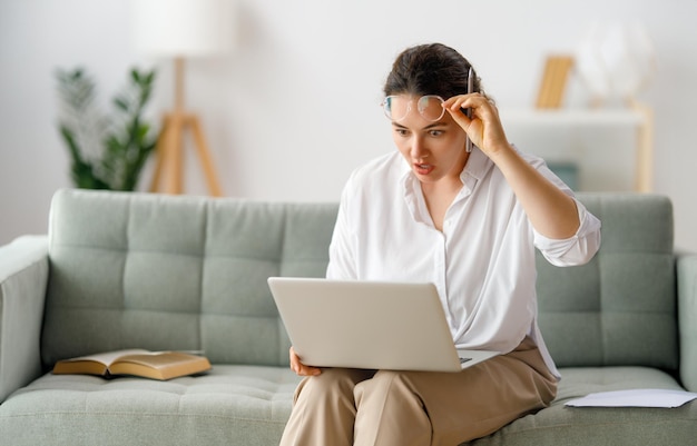 Vrouw die op laptop thuis werkt