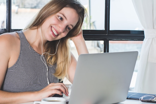 Vrouw die op laptop thuis werkt.