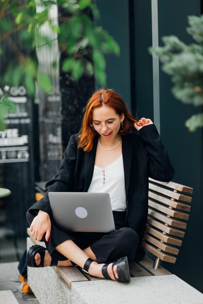 Vrouw die op laptop werkt en typt terwijl ze in café koffie drinkt