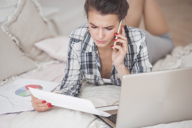 Vrouw die op laptop werkt. Externe medewerker binnenshuis.