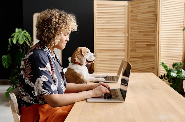 Vrouw die op laptop werkt met haar hond