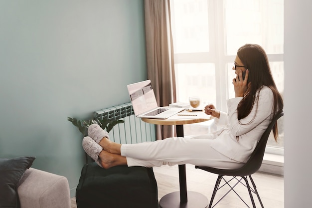 Vrouw die op laptop werkt vanuit huis