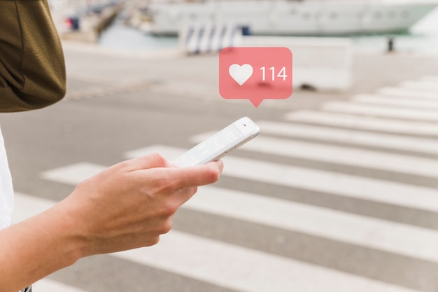 Vrouw die op mobiele telefoon met het symbool van de hartvorm babbelt