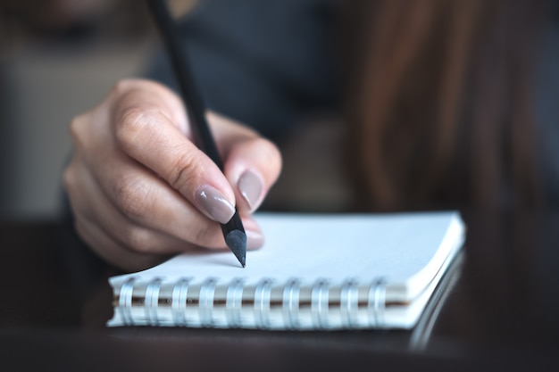 Vrouw die op notitieboekje schrijft