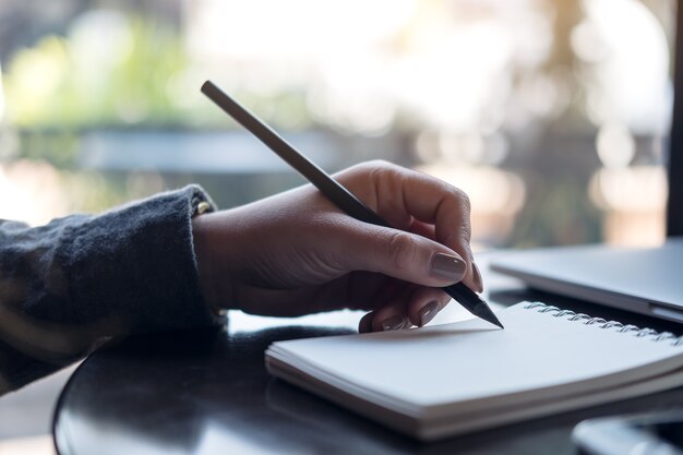 Vrouw die op notitieboekje schrijft