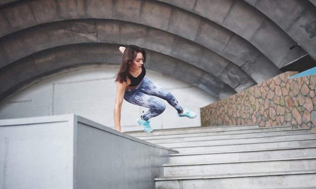 Vrouw die parkour in de stad doet