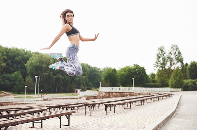 Vrouw die parkour in de stad op een zonnige dag doet