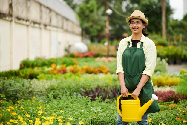 Vrouw die planten en bloemen water geeft