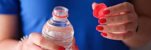 Vrouw die plastic fles opent met schoon water