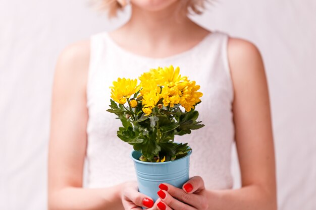 vrouw die pot van gele bloem