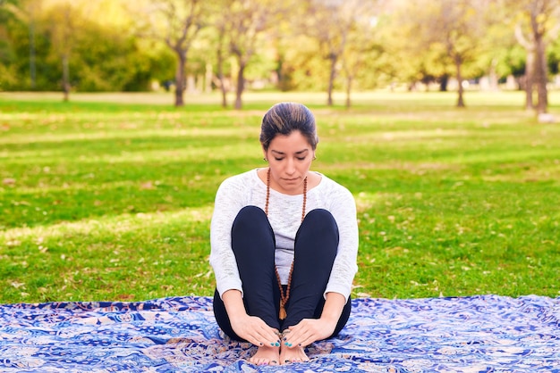 vrouw die reiki en yoga doet in een parkchakra pose