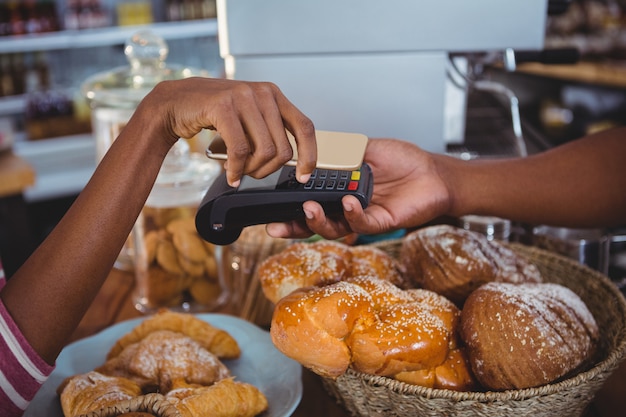 Vrouw die rekening betalen door smartphone die nfc technologie gebruiken