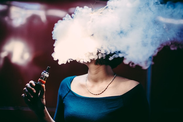 Vrouw die rook uitstraalt terwijl ze thuis rookt