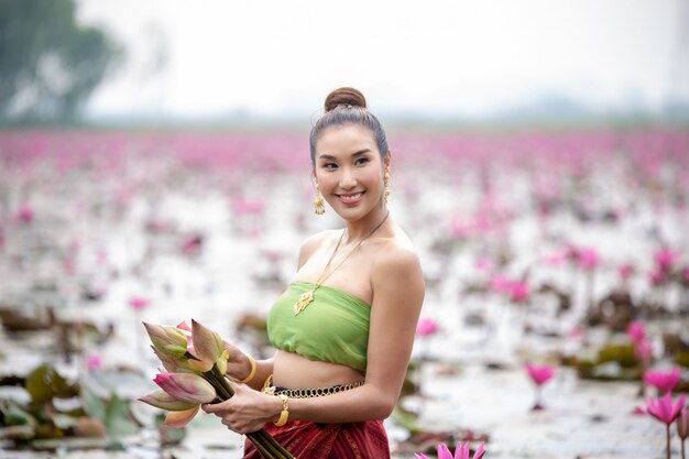 Foto vrouw die roze bloem in meer houdt