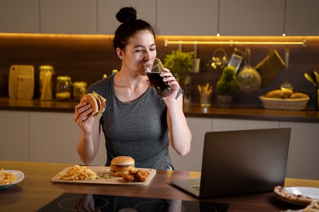 Vrouw die 's avonds laat ongezond voedsel eet