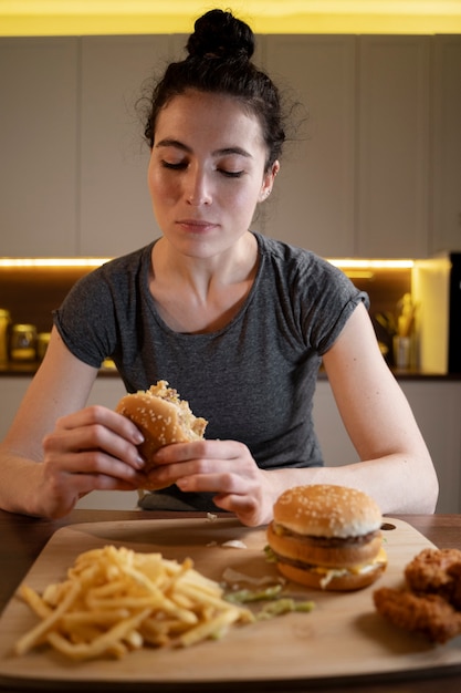 Vrouw die 's avonds laat ongezond voedsel eet