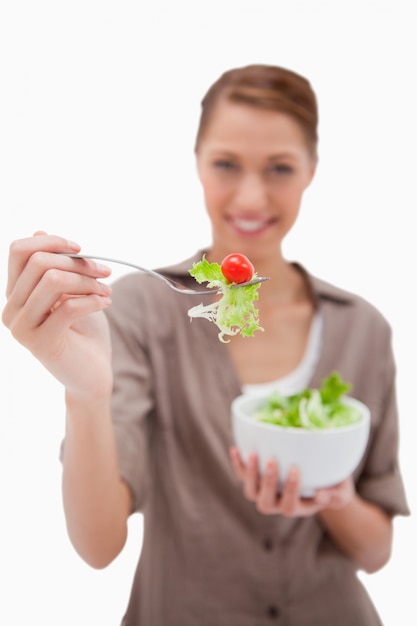 Vrouw die salade op een vork aanbiedt