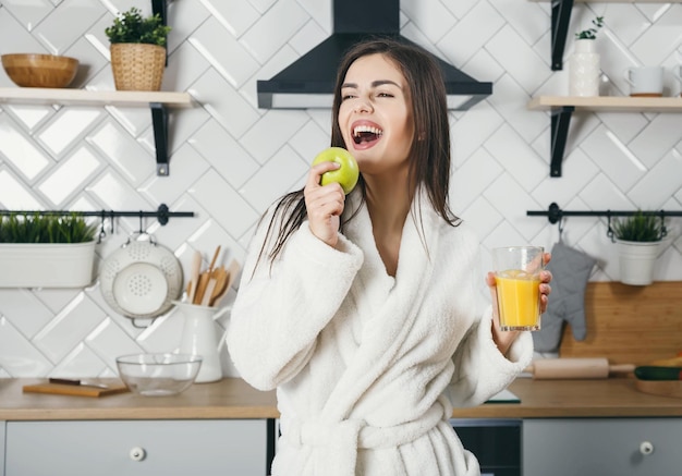 Vrouw die sap vasthoudt en een lied zingt bij de appel