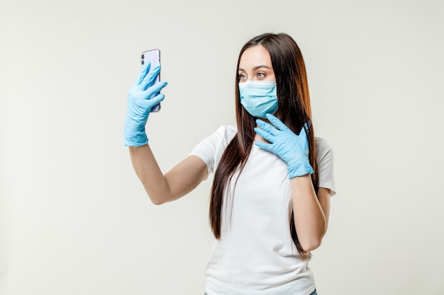 Foto vrouw die selfie dragend masker en handschoenen maken