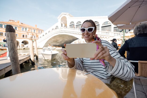 Vrouw die selfie neemt op terras in Venetië, Italië