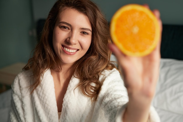 Vrouw die sinaasappel toont bij camera