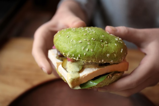 Vrouw die smakelijke groene sandwichclose-up eet